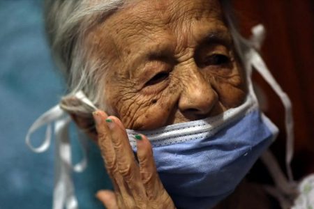 Maria Araque, 90, wears a protective mask at her house during the nationwide quarantine due to the coronavirus disease (COVID-19) outbreak in Caracas, Venezuela March 25, 2020. Picture taken March 25, 2020. REUTERS/ Manaure Quintero
