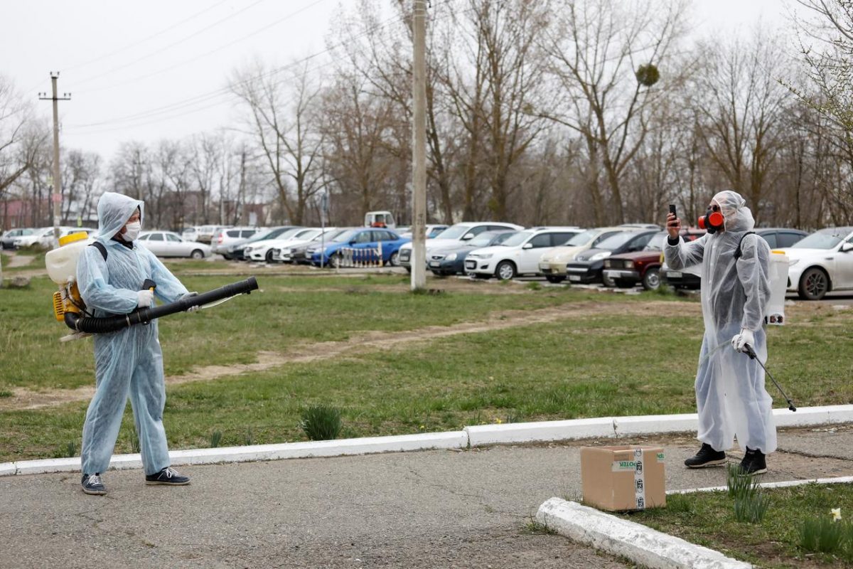 Specialists wearing protective gear take pictures while sanitizing the territory of a local hospital to prevent the spread of the coronavirus disease (COVID-19) in the town of Mikhaylovsk in Stavropol region, Russia April 3, 2020. REUTERS/Eduard Korniyenko