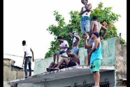 Denham Town residents gathered on a roof.