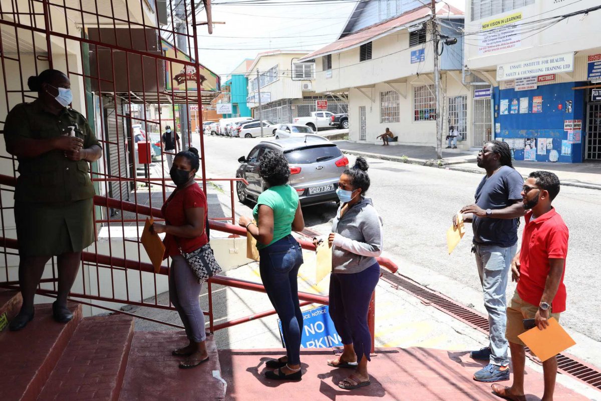 Members of the public wait in line outside TTPost on Coffee Street, San Fernando, to drop off their forms for the Salary Relief Grant, last week Tuesday.
