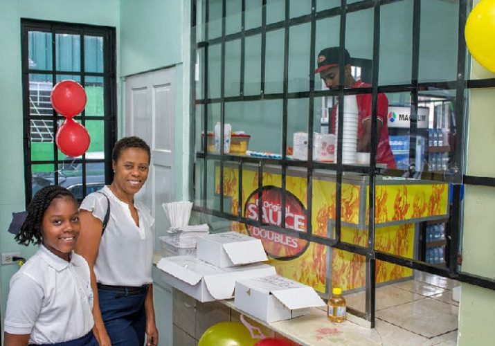 awaiting service: In this recent photo customers await service inside “D’Original Sauce Doubles” shop at Eastern Main Road, Curepe.