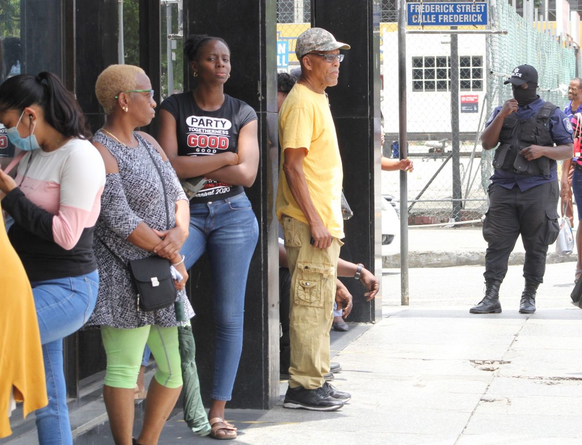 A police officer ensures social distancing outside Scotiabank on Independence Square, Port-of-Spain, on Friday.