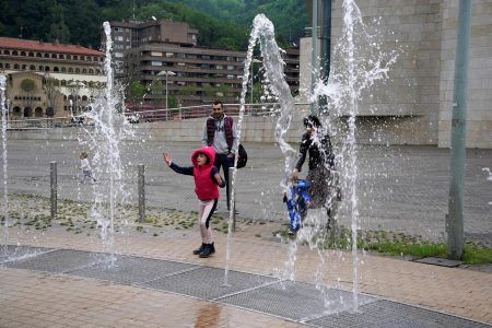 A girl plays in a fountain at the Guggenheim Museum, after restrictions were partially lifted for children for the first time in six weeks, during the coronavirus disease (COVID-19) outbreak in Bilbao, Spain, April 26, 2020. REUTERS/Vincent West
