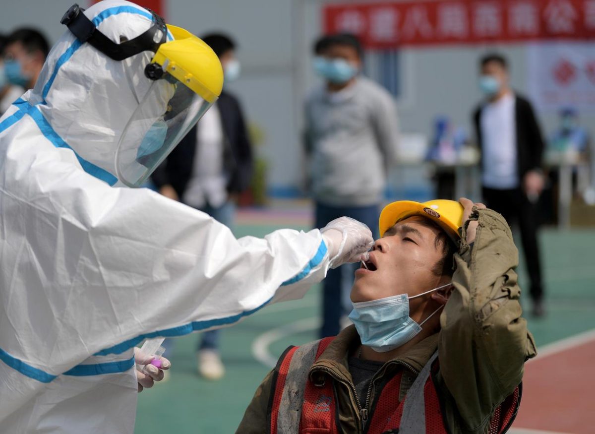 A worker in a protective suit collects a swab from a construction worker for nucleic acid test in Wuhan, Hubei province, the epicentre of the novel coronavirus disease (COVID-19) outbreak in China, April 7, 2020. China Daily via REUTERS/File Photo