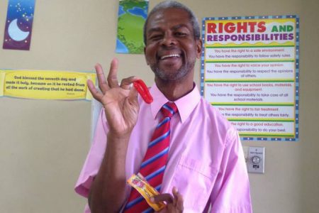 Derry Etkins in 2014 displaying a prized gift from one of his classes, an edible bracelet, which said, “So Sweet!”