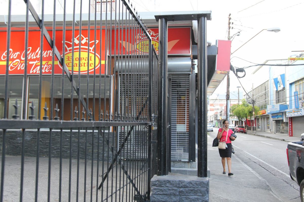 A pedestrian walks by the closed Royal Castle outlet on Frederick Street, Port-of-Spain yesterday.