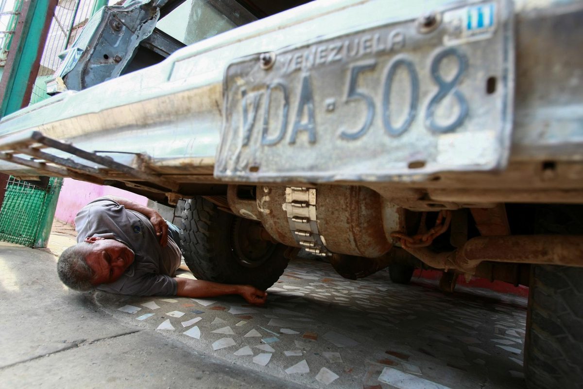 Alfredo Gonzalez checks a cooking gas canister beneath his car, which is used to run his vehicle instead of fuel, as Venezuelans are struggling to cope with chronic fuel shortage, in Maracaibo, Venezuela May 8, 2020. REUTERS/Isaac Urrutia