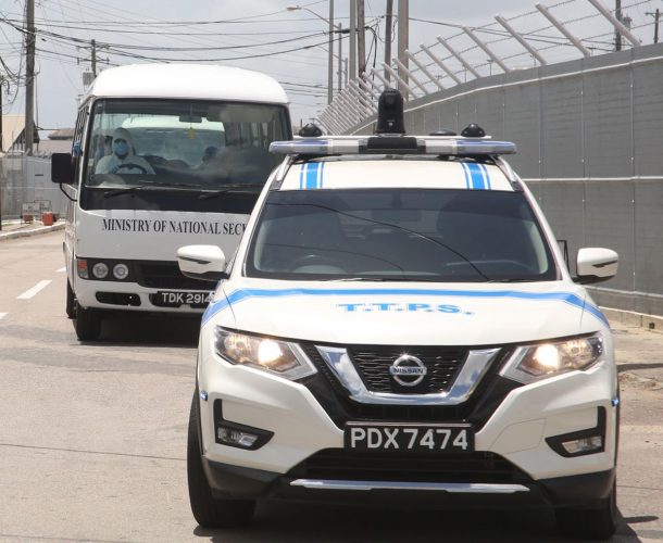 Police escort a vehicle with returning T&T nationals from Piarco International Airport to the National Racquet Centre, Step Down Facility in Tacarigua yesterday.