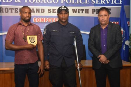 Gift for good SAMARITAN: Kevon Neptune, left, PC Shane Smith and Police Commissioner Gary Griffith following an award ceremony on Wednesday when Neptune was recognised for his efforts in assisting Smith after a road traffic accident in March.