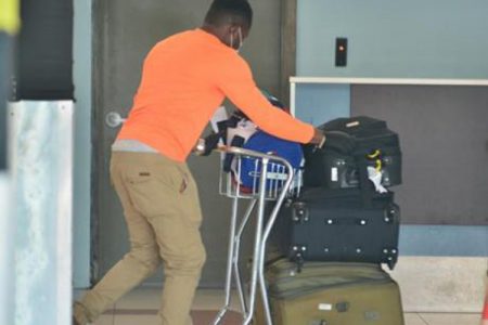 File. A Jamaican man who arrived on this morning's JetBlue flight from the United States, pushes his luggage through the Norman Manley Airport in Kingston. He was one of 96 Jamaicans who arrived under the government's repatriation programme to assist some 5,000 Jamaicans stranded overseas to return to the country.