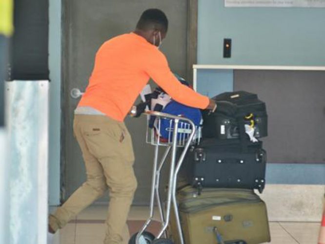 File. A Jamaican man who arrived on this morning's JetBlue flight from the United States, pushes his luggage through the Norman Manley Airport in Kingston. He was one of 96 Jamaicans who arrived under the government's repatriation programme to assist some 5,000 Jamaicans stranded overseas to return to the country.