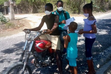 Keron King, Principal of Little Bay Primary School in Westmoreland, delivering and picking up homework by motorbike during the COVID-19 outbreak.
