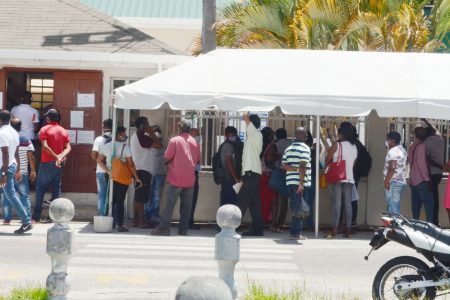 Masks and distance outside the Guyana Revenue Authority on Wednesday. (Orlando Charles photo)