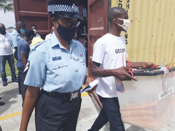 The start of the recount process yesterday morning. A ballot box being escorted into the Arthur Chung Conference Centre. (GECOM photo)