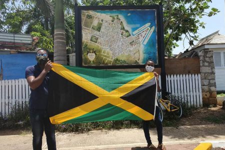 IN PHOTO: LaMar Spence and Britanya Nickle with a Jamaican flag at the Falmouth pier.