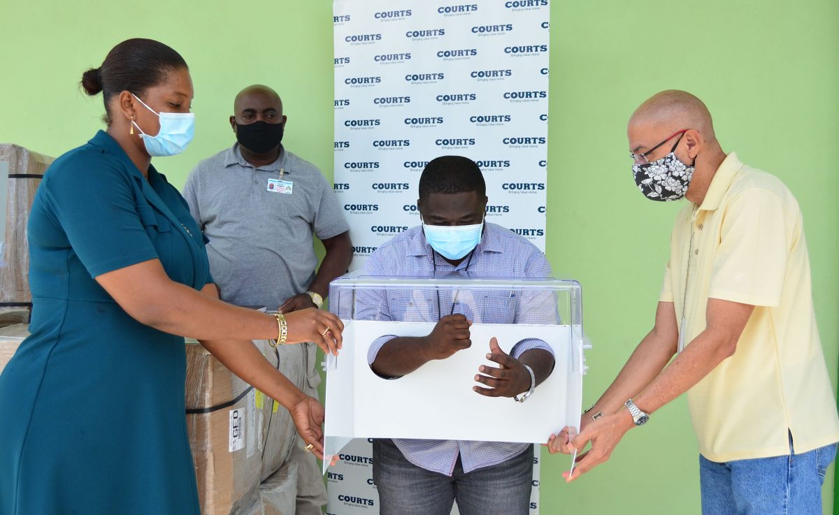 Courts Guyana yesterday donated 20 Aeroboxes to the Ministry of Public Health to aid in the protection of frontline health care workers. Here, Dr Leston Payne, Deputy Director of Health Emergency Operations Centre (HEOC), demonstrates how the Aerobox is used.  (Photo by Orlando Charles) 