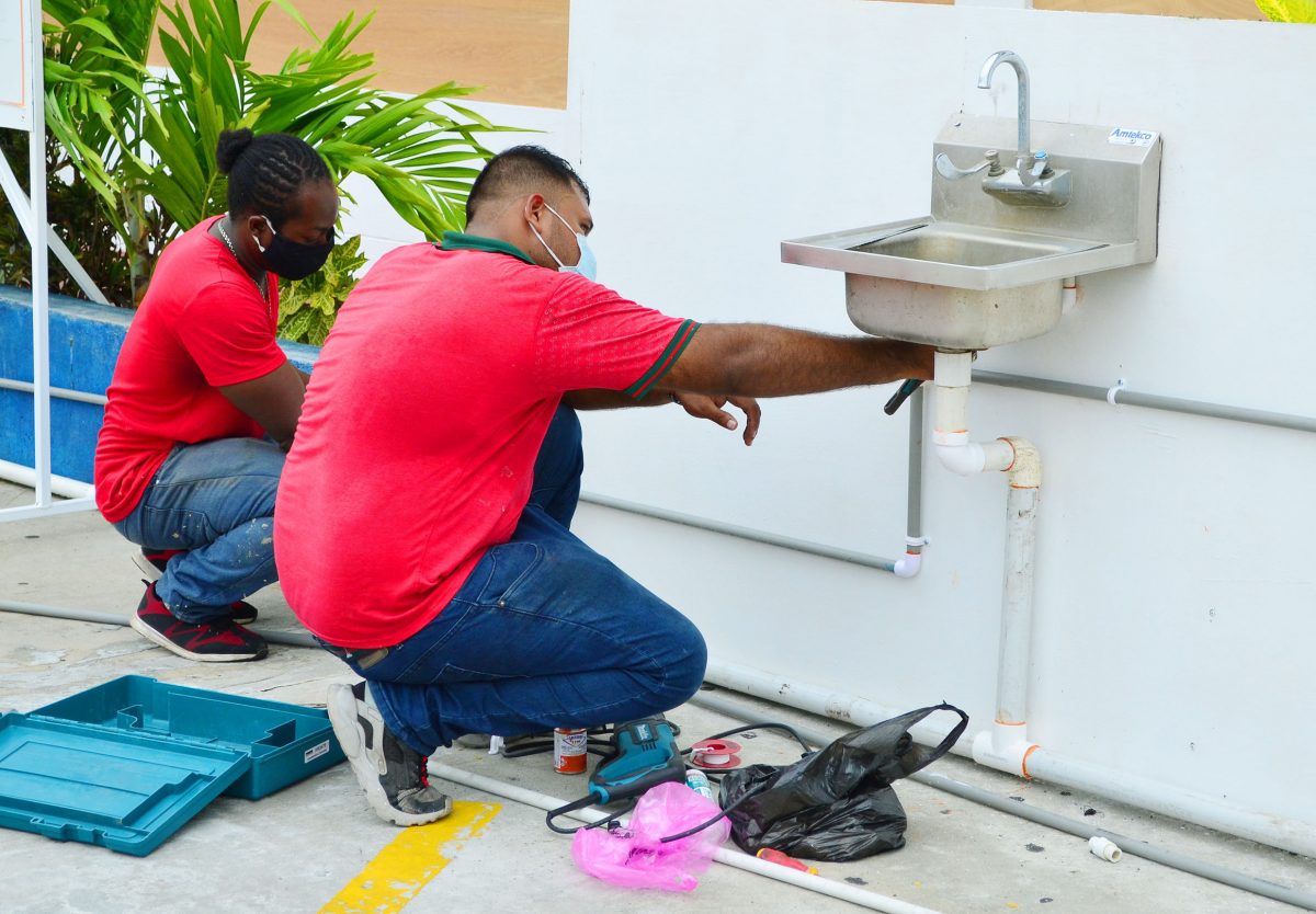 Workers installing a sink at the entrance of the Giftland Mall