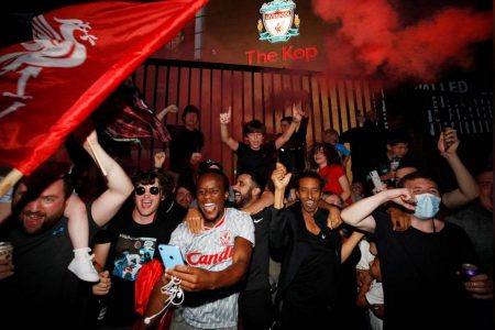 Liverpool fans celebrate winning the Premier League outside Anfield after Chelsea won their match against Manchester City yesterday. (REUTERS/Phil Noble)