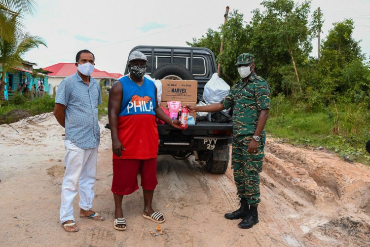 CDC Director General Lt. Col. Kester Craig (right) hands over hampers to Byron Kendall, District Community Development Officer, Region 10. (DPI photo)