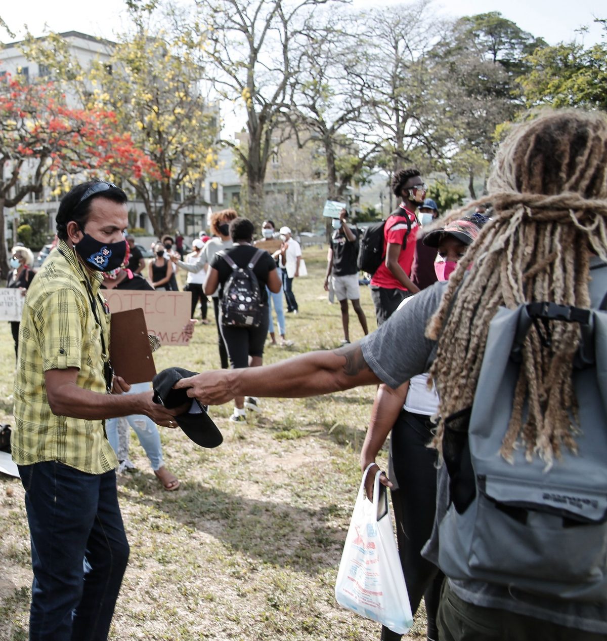 A protestor, right, returns the cap which Ian Smart took from a TTPS cameraman to a plainclothes officer during the Black Lives Matter protest at the Queen’s Park Savannah, Port-of-Spain, on Monday.