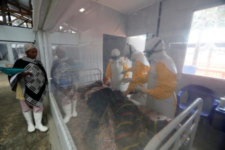 FILE PHOTO: Moise Vaghemi, 33, (C) an Ebola survivor who works as a nurse, cares for a patient who is suspected to be suffering from Ebola, inside the Biosecure Emergency Care Unit (CUBE) at the Ebola treatment centre in Katwa, near Butembo, in the Democratic Republic of Congo, October 3, 2019. REUTERS/Zohra Bensemra/File Photo
