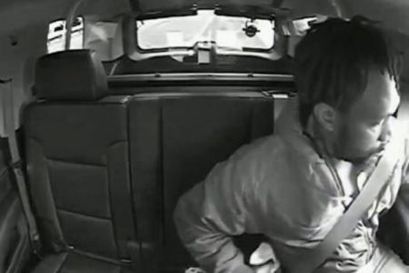 This image taken from May 23, 2020, video shows Maurice Gordon of Poughkeepsie, New York, as he unbuckles his seatbelt before exiting a New Jersey State Trooper's vehicle in Bass River, New Jersey. (New Jersey Attorney General's Office via AP)