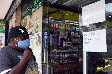 prepared: A customer adjusts his mask as he enters a business place on Mucurapo Street, San Fernando, yesterday.