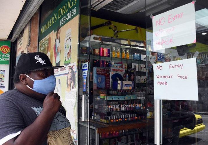 prepared: A customer adjusts his mask as he enters a business place on Mucurapo Street, San Fernando, yesterday.