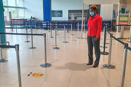 Nadia Lyn, MBJ Airports Limited corporate coordinator, looks at physical distancing markers on the floor inside the security boarding pass checkpoint area of the Sangster International Airport in Montego Bay, St James.