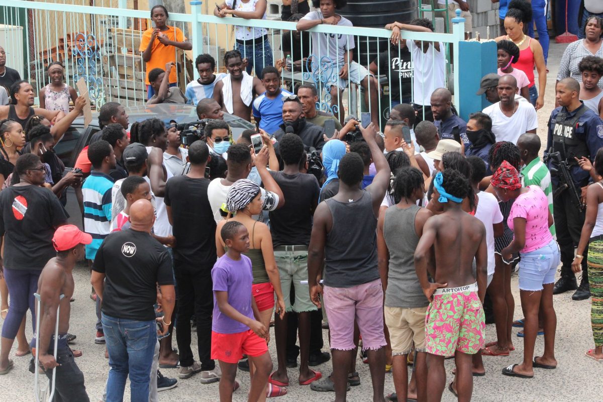 Inspector Roger Alexander speaks to residents of Second Caledonia, Morvant during their protest yesterday over the police shootings in the area on Saturday.