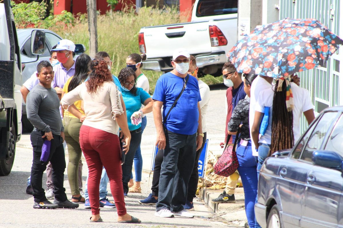 Venezuelan nationals wait in line outside the Immigration Office in San Fernando on Tuesday.