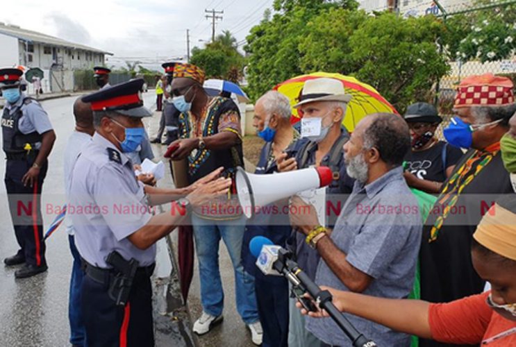 David Denny (right) and Lalu Hanuman of The Caribbean Movement for Peace and Integration speaking with police this morning during the protest outside the American Embassy. (Pictures by Reco Moore)