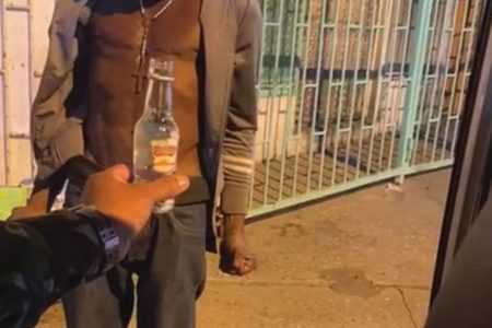 A soldier hands a bottle of Puncheon to a homeless man while on patrol in Port-of-Spain earlier this year.