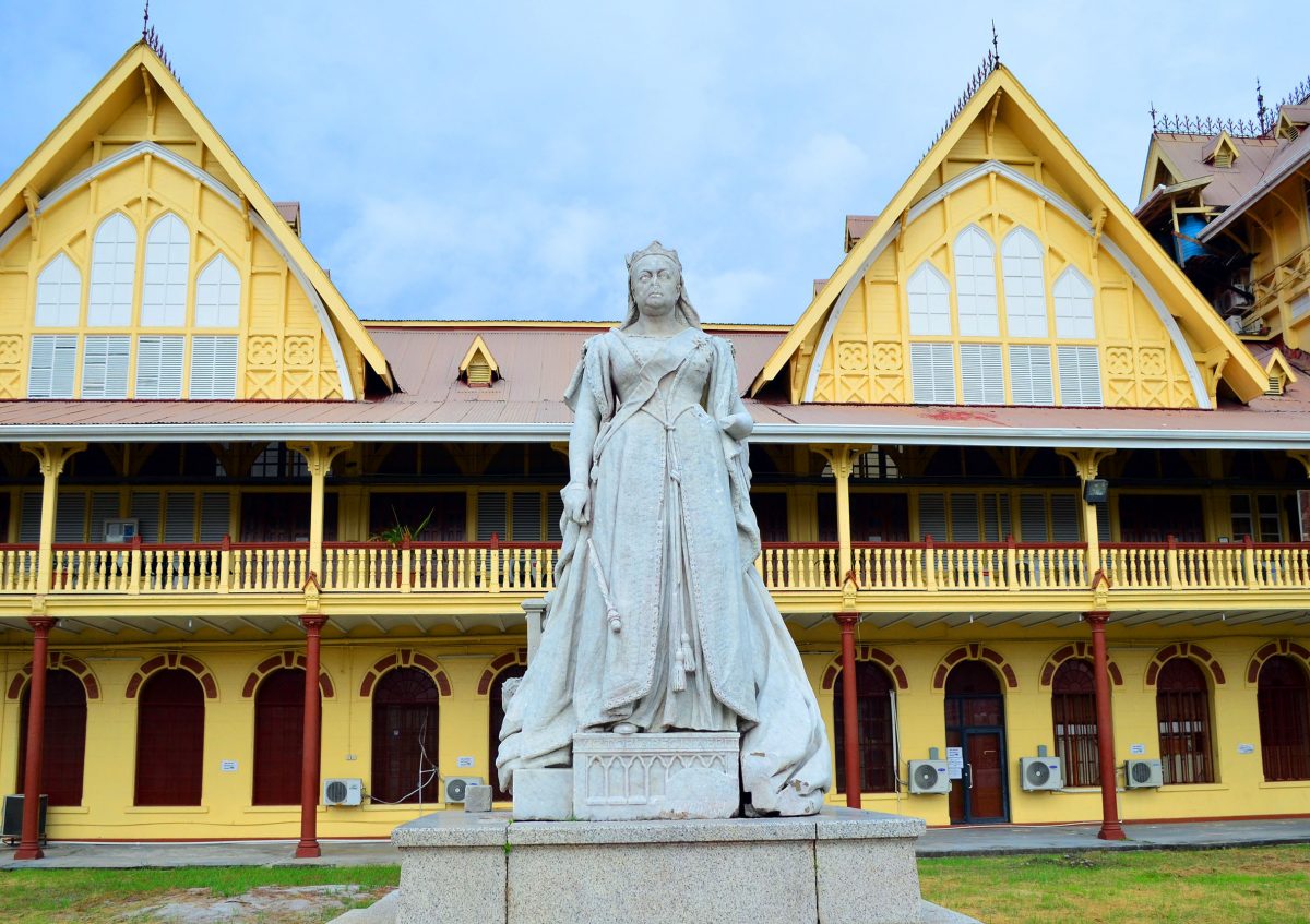 As campaigns across the globe to remove statues of historical figures with links to slavery and colonisation gain traction, local attention has turned to one of Guyana’s most famous relics of its colonial past: The statue of Queen Victoria (seen here on the lawns of the High Court in Georgetown.)  Some local activists have started to call for the removal of the monument and that of Mahatma Gandhi in the Promenade Gardens. Gandhi has been accused of being “a fascist, racist and sexual predator,” while Victoria has been condemned for being monarch during the great expansion of the British Empire. According to a brief history of the monument published by historian Nigel Westmaas, the Queen Victoria Statue was sculpted by Henry Richard Hope-Pinker and commissioned in 1887. In 1894 it was unveiled outside the “Victoria law courts” in Georgetown for the first time. Victoria’s head was removed in 1954 by an explosive device in then British Guiana. In 2018 the statue was “vandalized” with red paint. (Photo by Orlando Charles) 