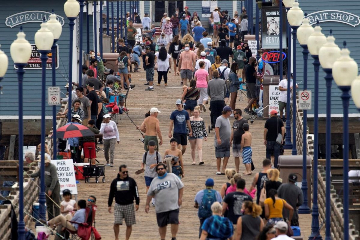 FILE PHOTO: Few people wear masks as they walk on the beach pier during the global outbreak of the coronavirus disease (COVID-19) in Oceanside, California, U.S., June 22, 2020. REUTERS/Mike Blake
