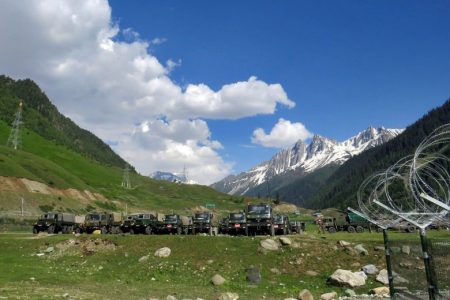 Indian army soldiers walk past their parked trucks at a makeshift transit camp before heading to Ladakh, near Baltal, southeast of Srinagar, June 16, 2020. REUTERS/StringerReuters
