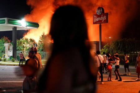 People watch as a Wendy’s burns following a rally against racial inequality and the police shooting death of Rayshard Brooks, in Atlanta, Georgia, U.S. June 13, 2020. REUTERS/Elijah Nouvelage