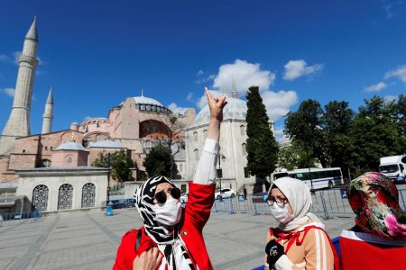 A woman gestures in front of the Hagia Sophia or Ayasofya, after a court decision that paves the way for it to be converted from a museum back into a mosque, in Istanbul, Turkey, July 10, 2020. REUTERS/Murad Sezer
