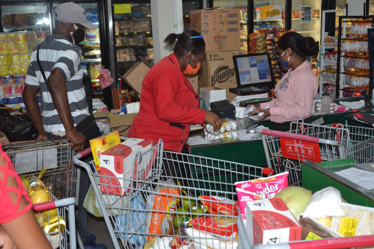 Staff at the Survival Supermarket assisting with checking and packing the trolleys for the beneficiaries. (DPI Photo)