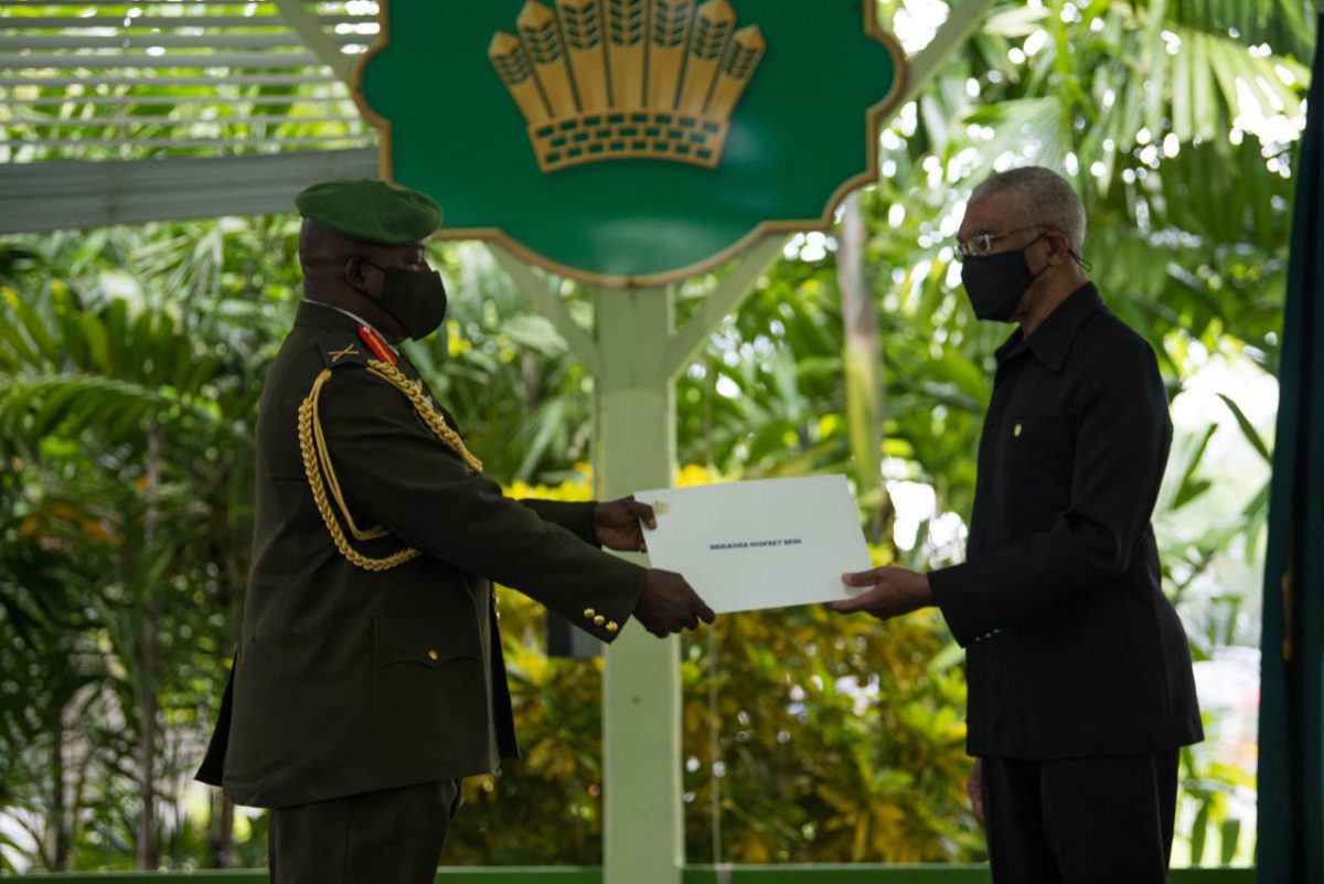 President David Granger presents the Instrument to Brigadier Godfrey Bess, Chief of Staff of the Guyana Defence Force during the Swearing-in Ceremony, yesterday, in the Baridi Benab at State House. (Ministry of the Presidency photo)