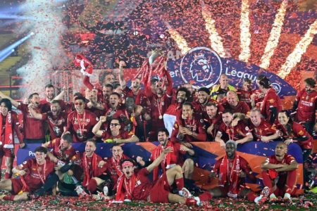 Liverpool players and staff pose with the trophy after winning the Premier League Photo: Pool via Reuters
