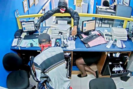 Masked robbers brandish weapons while making off with $3.2 million from the Whitehouse Money Shop branch of Jamaica National Bank on Tuesday.