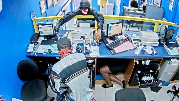 Masked robbers brandish weapons while making off with $3.2 million from the Whitehouse Money Shop branch of Jamaica National Bank on Tuesday.