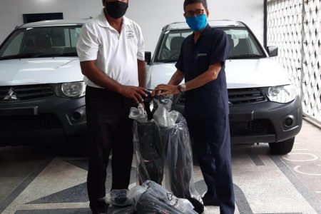 Colin Ming (right) presents Aleem Hussain with the products.
