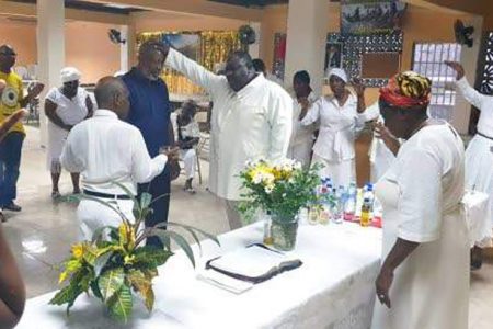 Head of the Apostolic Outreach Ministry Winston Farquharson (centre) lays hand on a congregant during an outreach service in Panama City, Panama. Farquharson says he and three other Jamaican missionaries are stranded in the country because of the coronavirus pandemic.