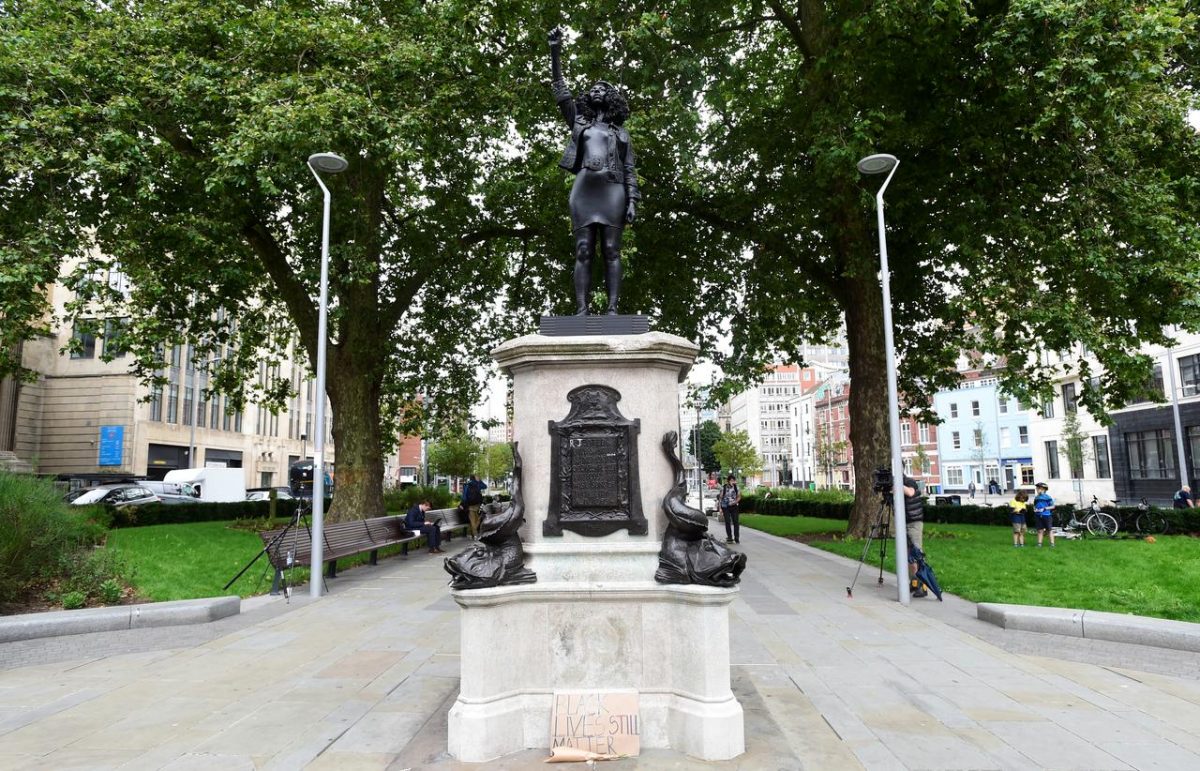Resident Jen Reid rising her fist stands on the empty plinth previously occupied by the statue of slave trader Edward Colston, in Bristol, Britain June 7, 2020, in this image obtained from social media. Courtesy of INSTAGRAM/@BIGGIESNUG/via REUTERS