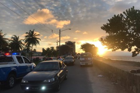 The police patrol vehicle with loudspeakers advising persons to remove from the seawall as it approached the curfew yesterday afternoon. 