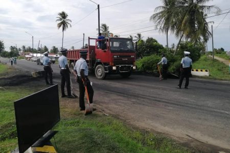 Police clearing the debris from the road at Mahaicony following the protest (Photo taken from the Regional Democratic Council, Region No.5 Facebook page)
