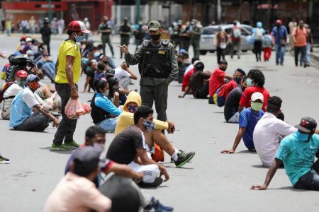 A member of Venezuela’s Bolivarian National Guard stands among people placed in the middle of the street in the low income neighbourhood of Petare as a punishment for disrespecting social distancing measures, amid the outbreak of the coronavirus disease (COVID-19), in Caracas, Venezuela August 5, 2020. (REUTERS/Manaure Quintero photo)