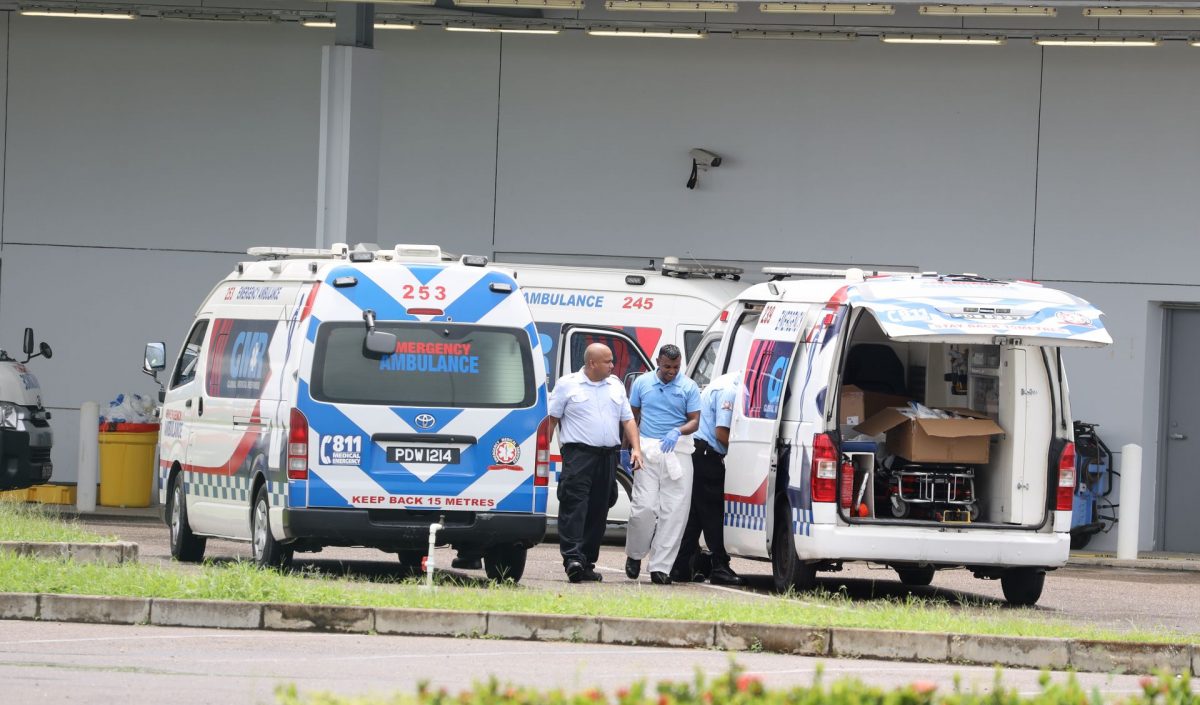 Emergency medical technicians mill around ambulances parked outside the Couva Hospital and Multi-Training Facility after dropping off COVID-19 patients yesterday.